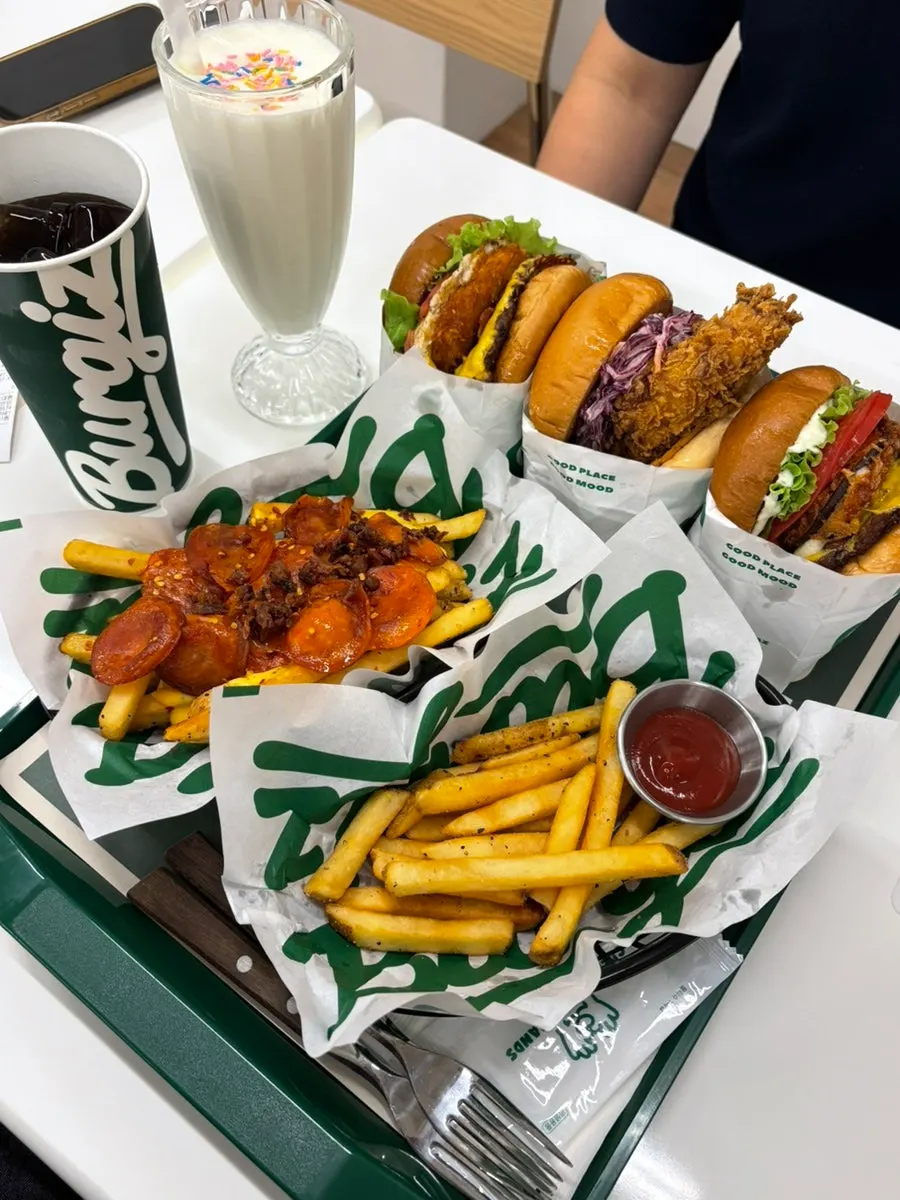 Table with burgers, sides, and drinks together