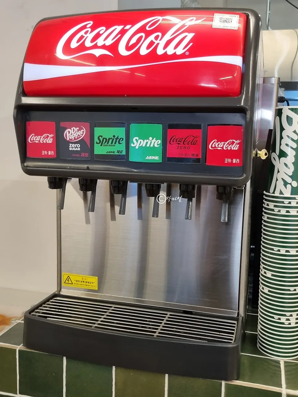Self-serve sauce and drink bar next to the counter