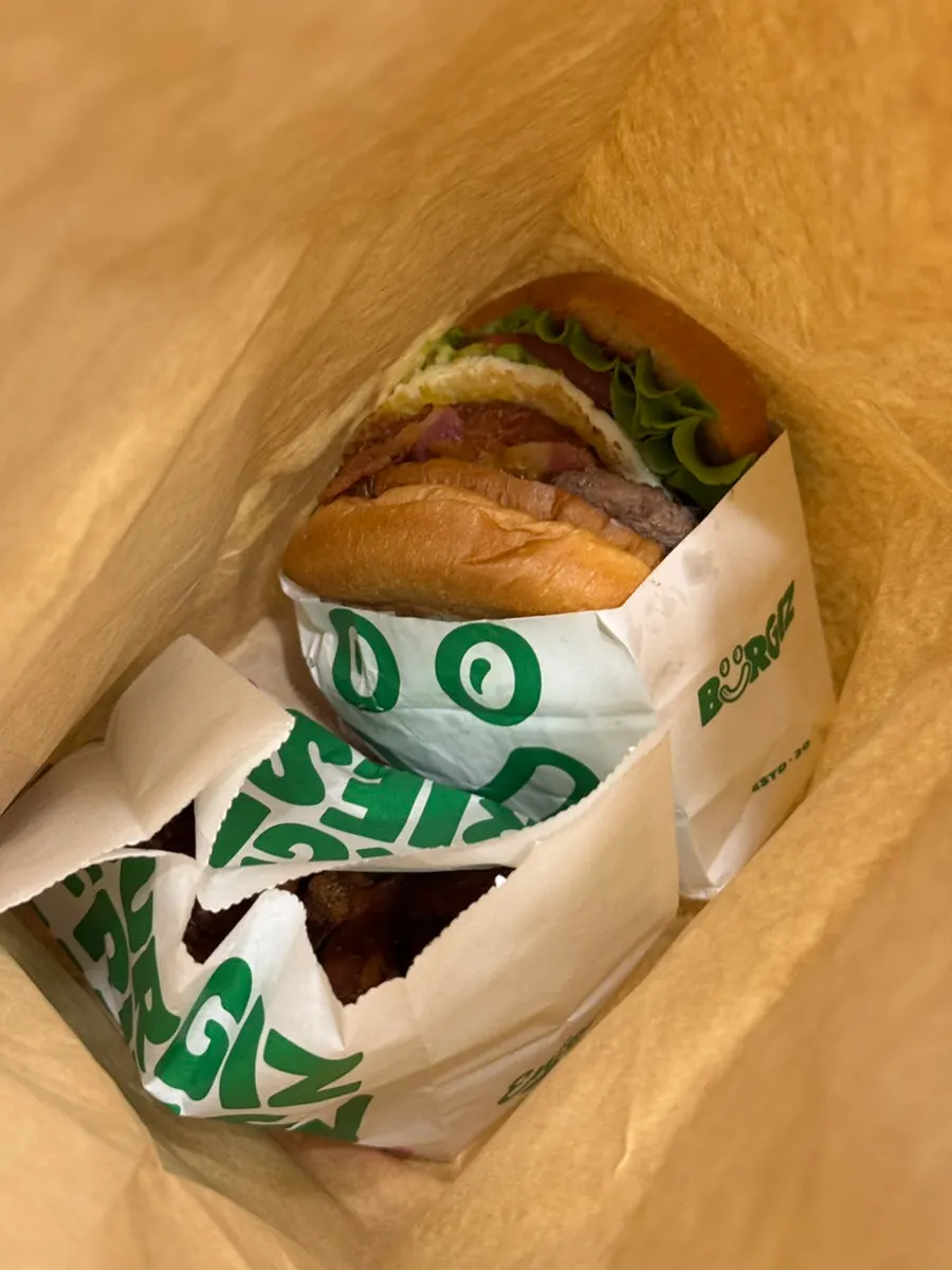 Full spread of takeout burger and sides from Buggies