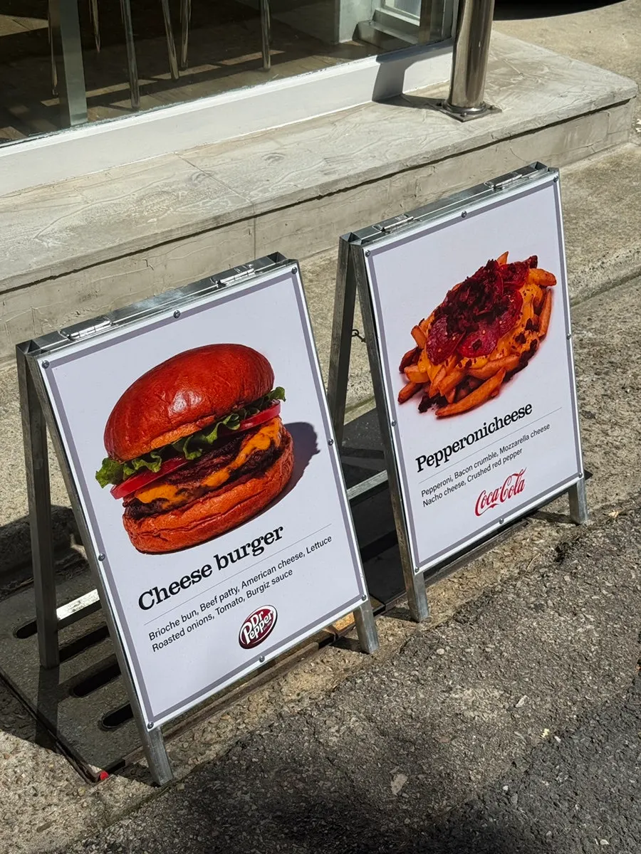 Outdoor menu board listing burger and side prices