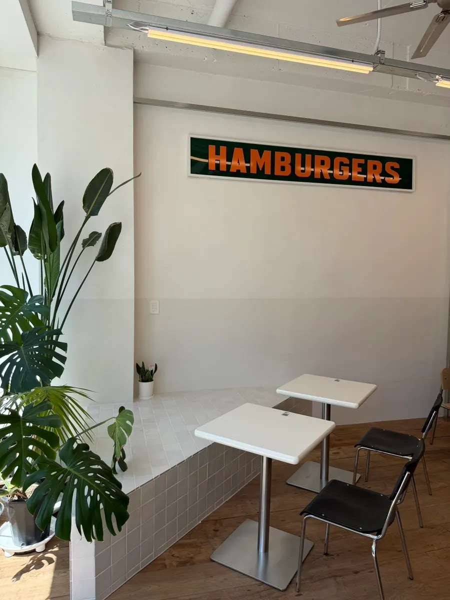 Wall interior with HAMBURGERS sign and merch decor