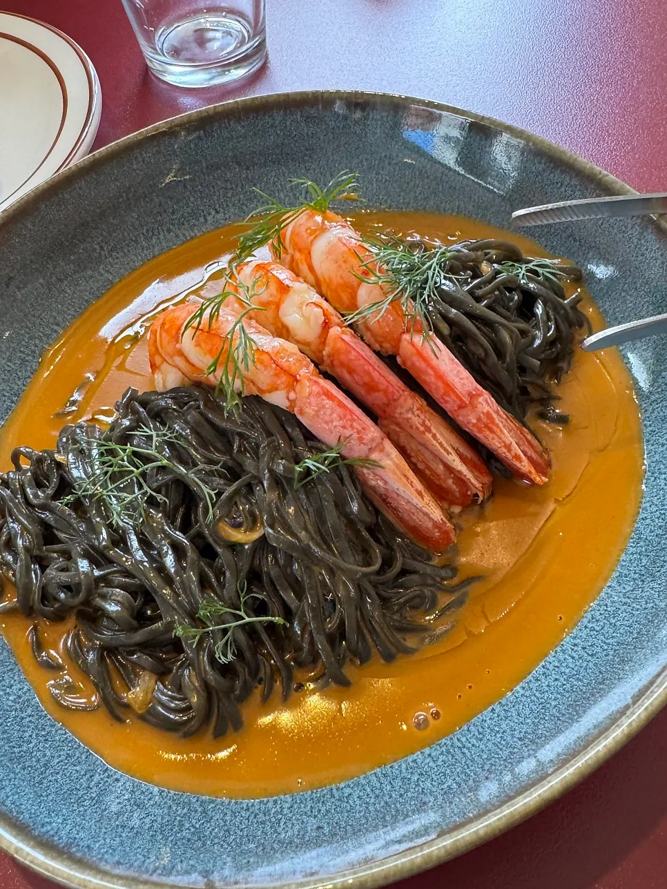 Bisque pasta topped with a large red shrimp