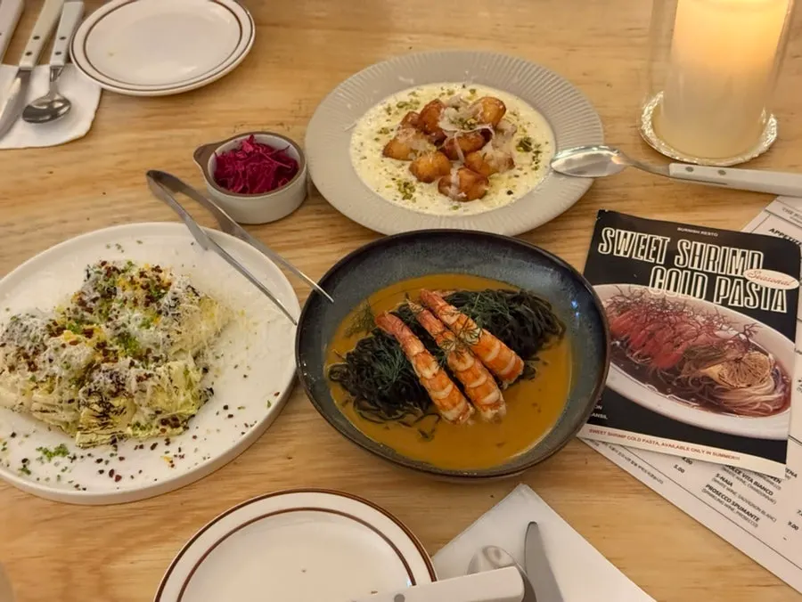 Table spread with napa cabbage salad, handmade gnocchi bites, and bisque pasta