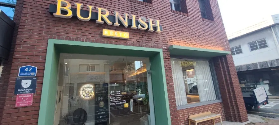 Exterior of Burnish Resto with red brick and green accents