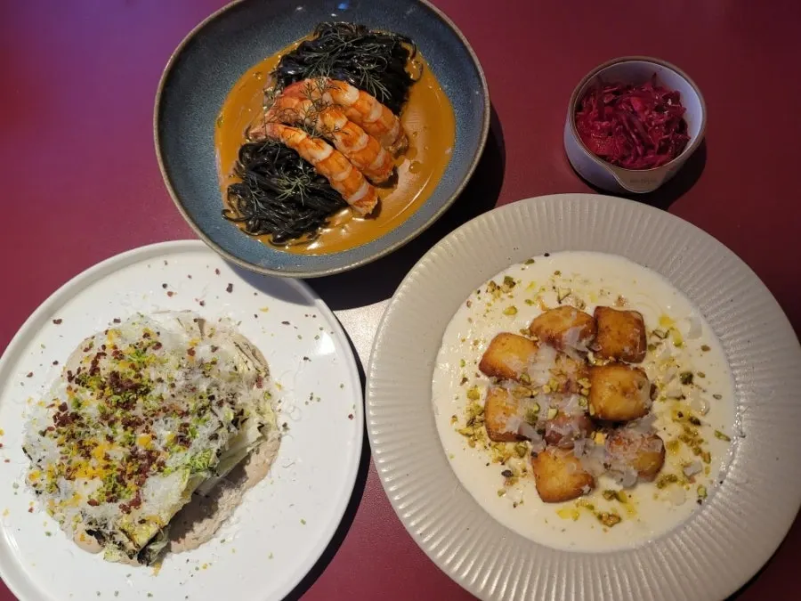 Table set with salad, pasta, and gnocchi dishes