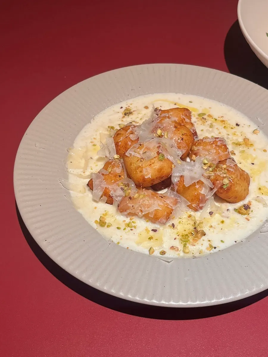 Close-up of gnocchi bites topped with pistachio