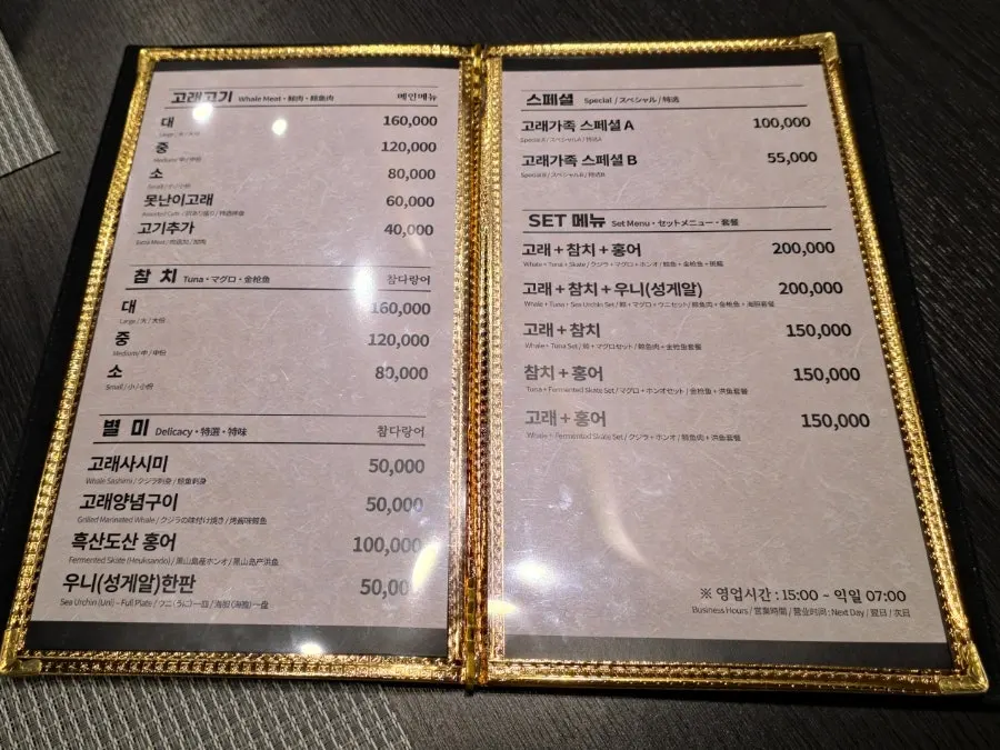 Menu board listing whale meat sizes, tuna, and skate