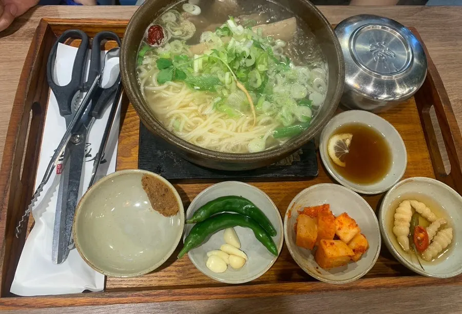 Galbitang and side dishes served on a brown tray