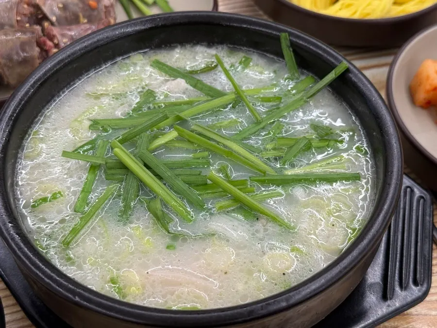 부추와 국수 사리를 넣은 돼지국밥