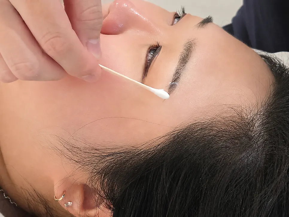색소를 닦아내고 마무리 제품을 바르는 모습