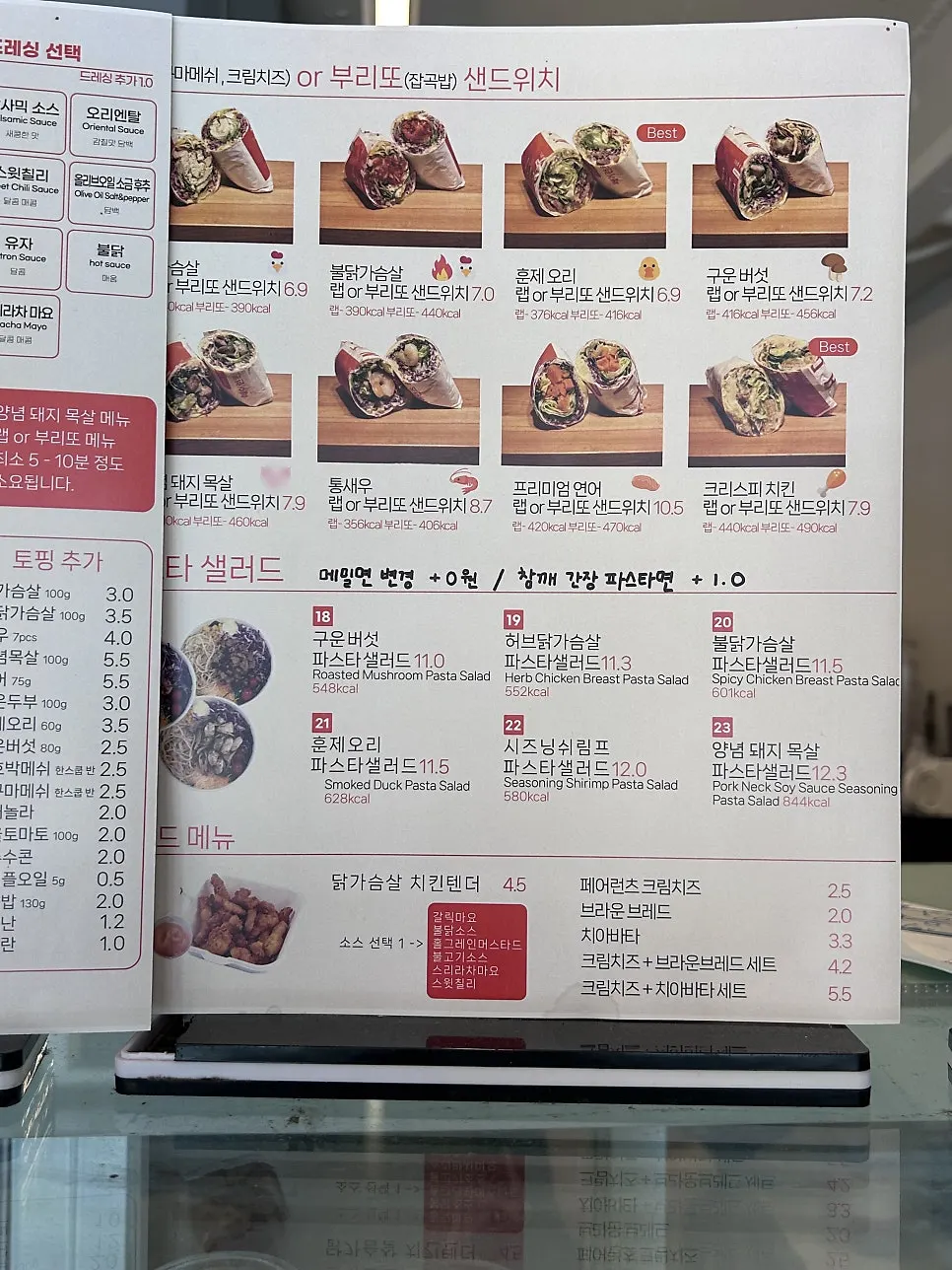 Menu board showing poke salad and wrap sandwich prices