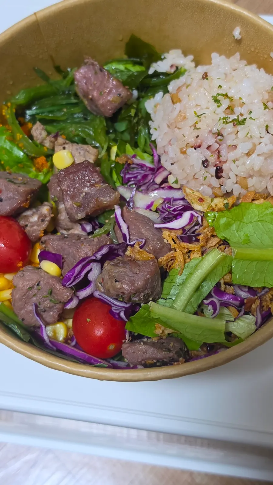 Beef flap steak poke topped with cherry tomatoes and corn