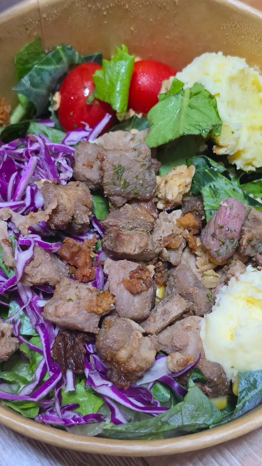 Close-up of a poke bowl with meat, vegetables, and rice