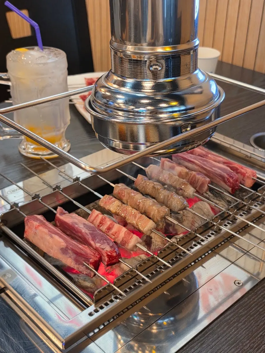 Lamb skewers and ribs on a rotating charcoal grill
