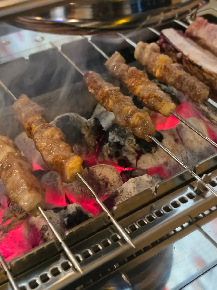 Lamb skewers browning over charcoal