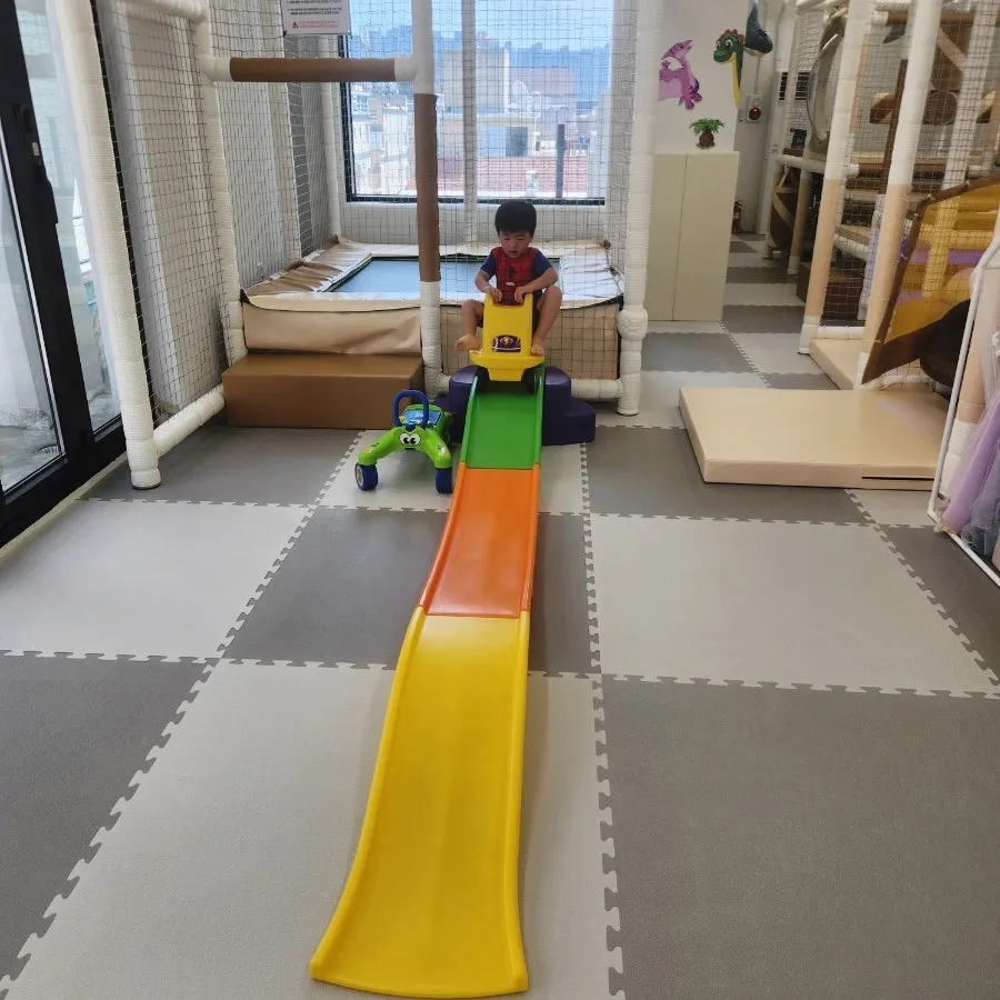 Ride-on car play facility that follows a rail