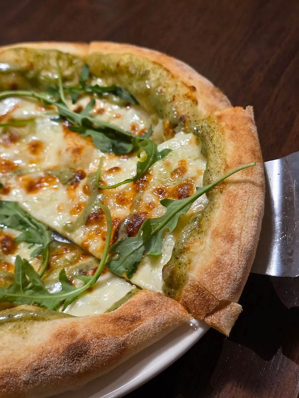 Margherita pizza topped with basil sauce