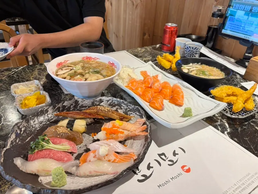 Full table spread with sushi, tempura and udon