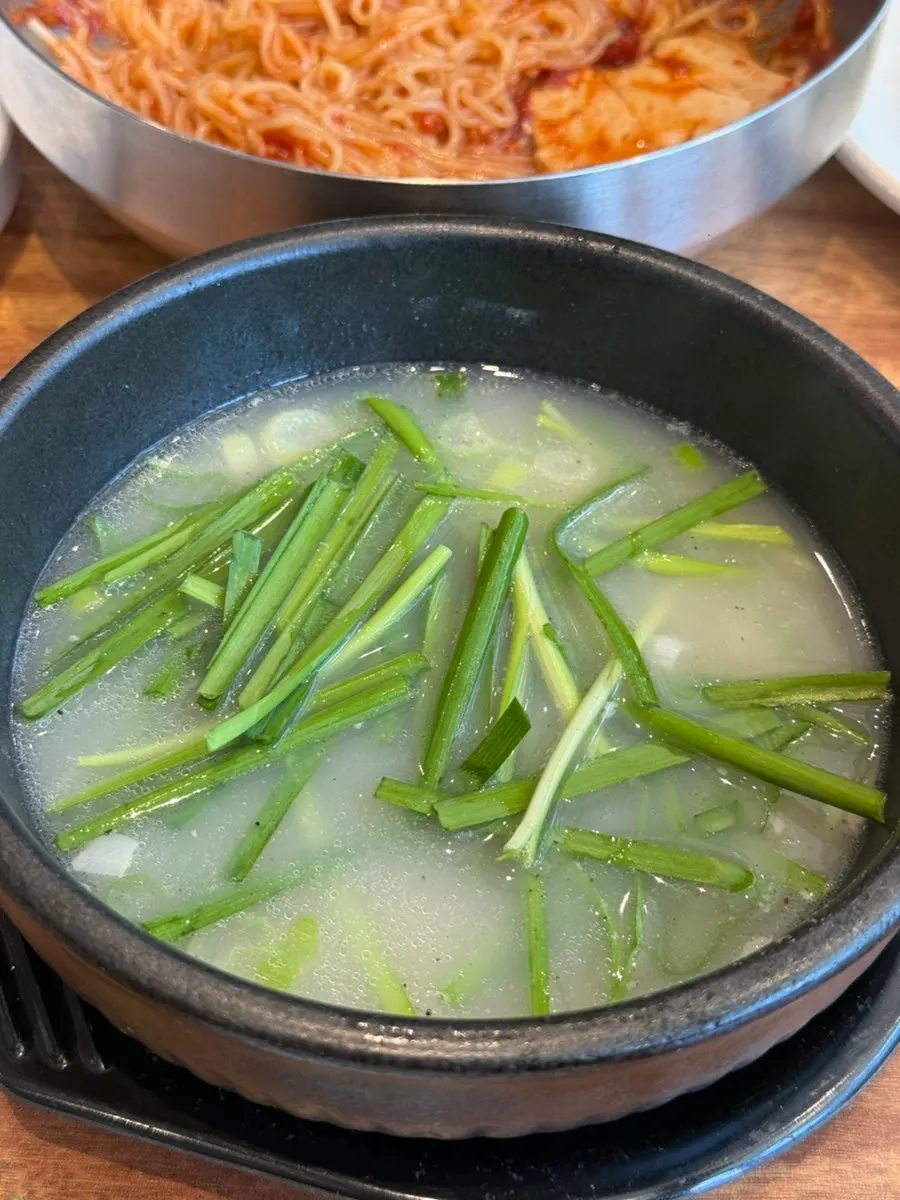Dwaeji gukbap broth with chives and salted shrimp added