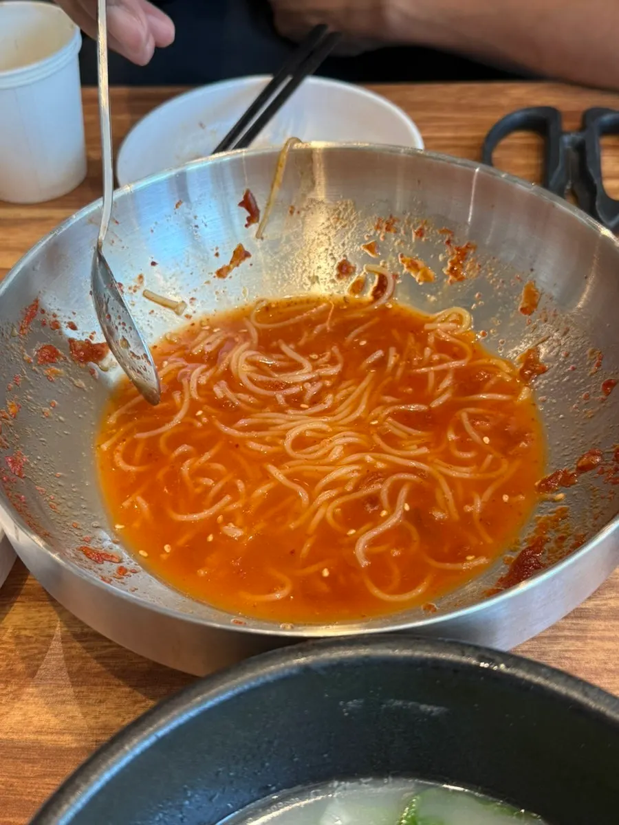 Soupy noodles made by pouring broth over leftover bibim milmyeon