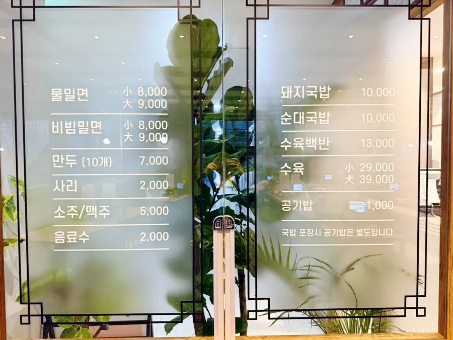 Menu board listing mul milmyeon, bibim milmyeon, dwaeji gukbap, and suyuk baekban