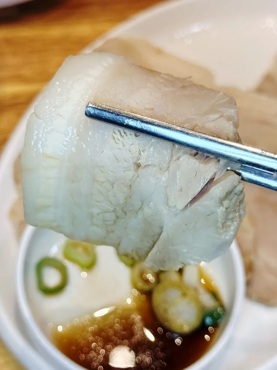 A piece of boiled pork dipped in salted shrimp sauce