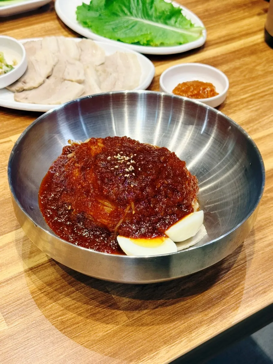 Small bibim milmyeon topped with cucumber and egg garnish