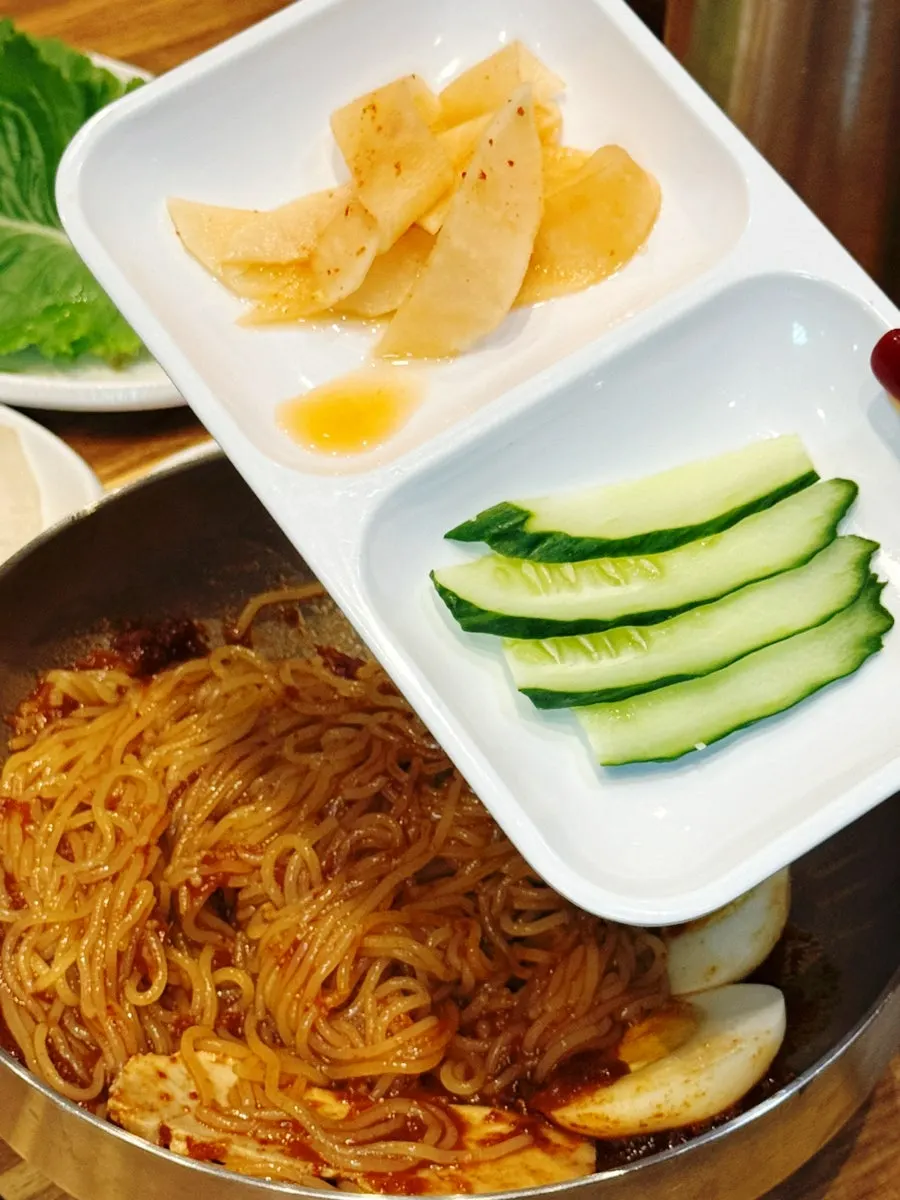 Bibim milmyeon noodles lifted with chopsticks