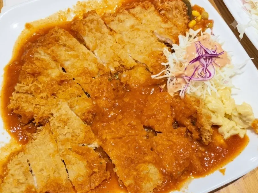 Plato de donkatsu acompañado de ensalada de repollo y macarrones