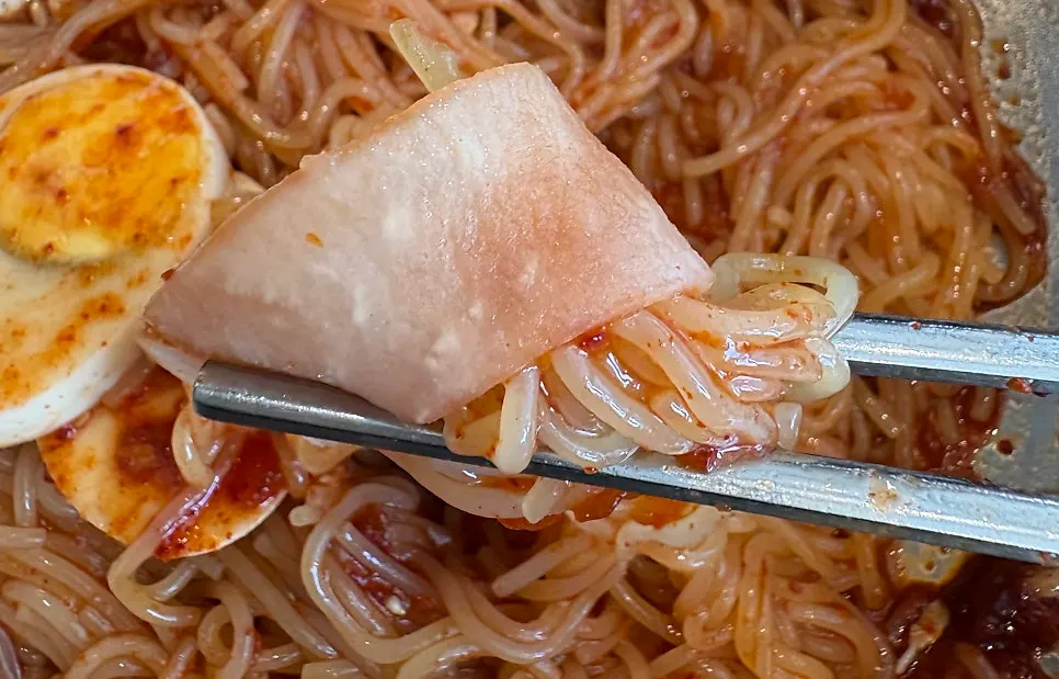 고기 고명 두 점이 올라간 비빔밀면