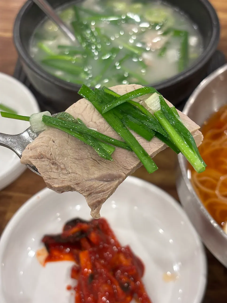 Stone bowl of dwaeji gukbap loaded with meat