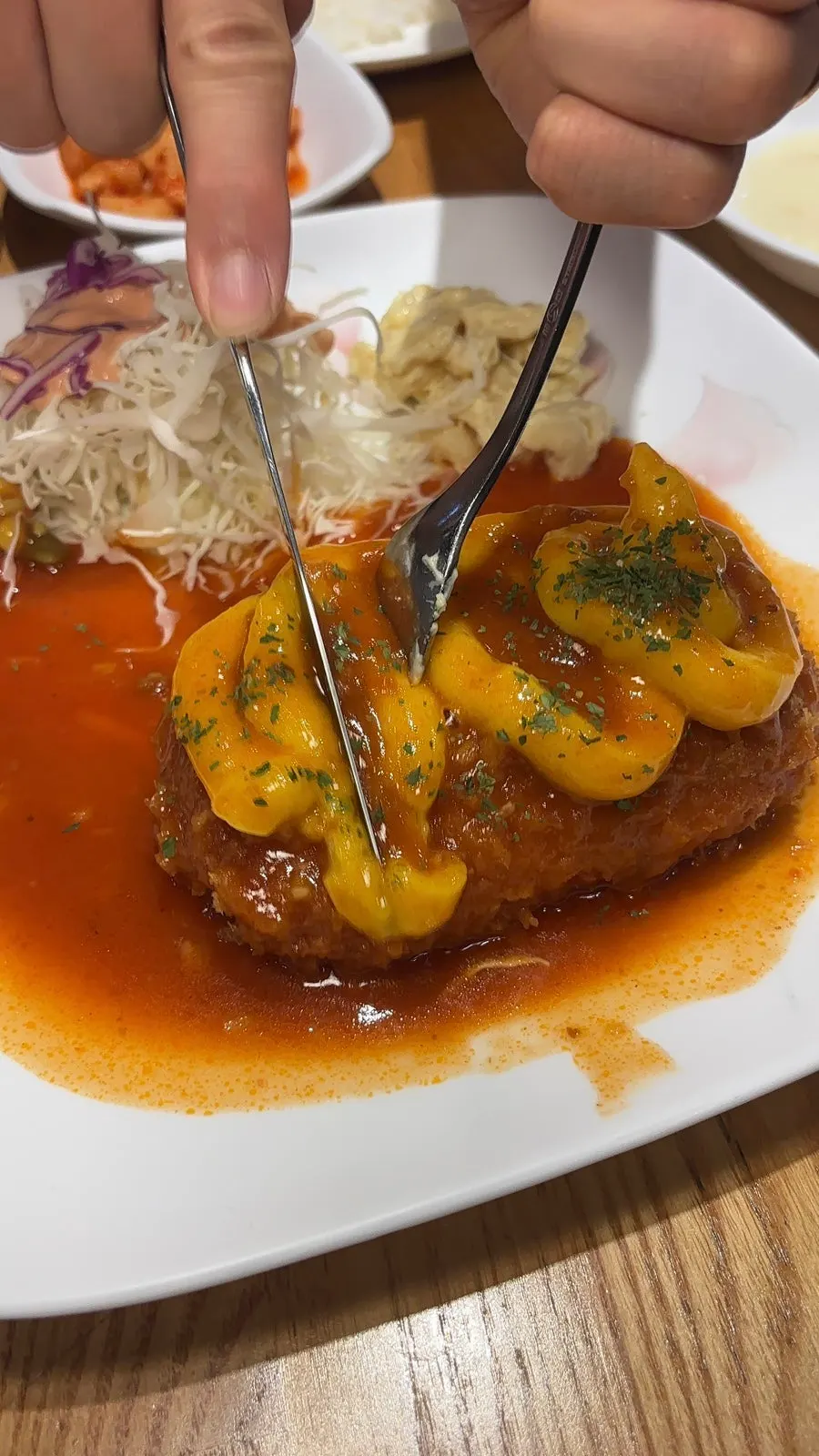 돈까스 조각에 치즈를 감아 든 모습