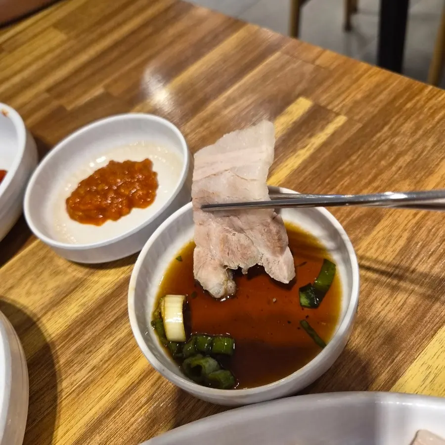 A piece of suyuk dipped in soy sauce