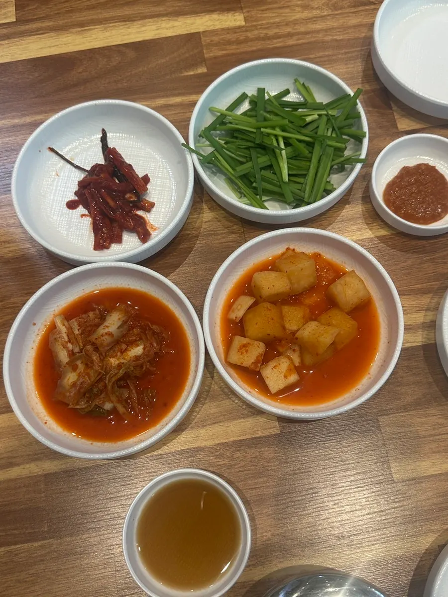 Side dishes including garlic, chili peppers, onion, and ssamjang