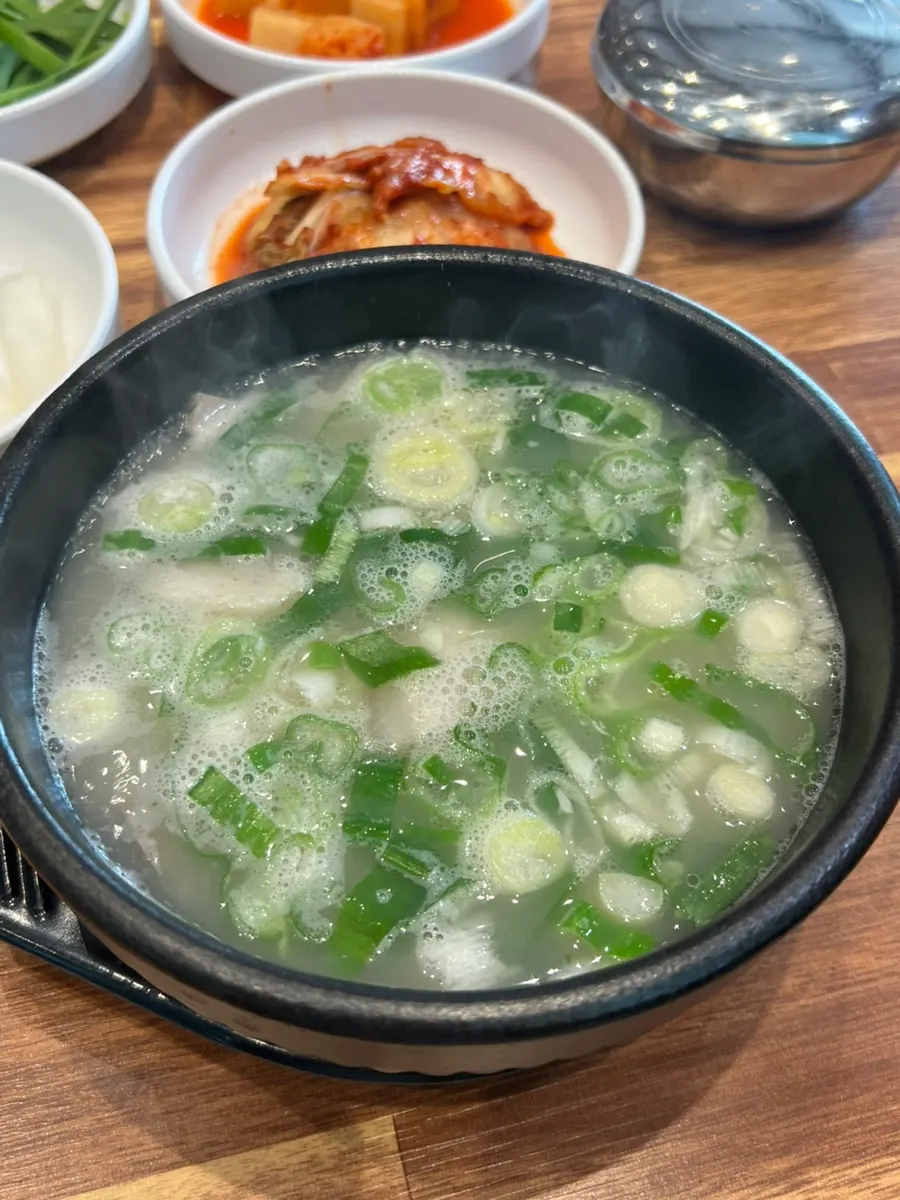 A spoonful of dwaeji gukbap loaded with meat