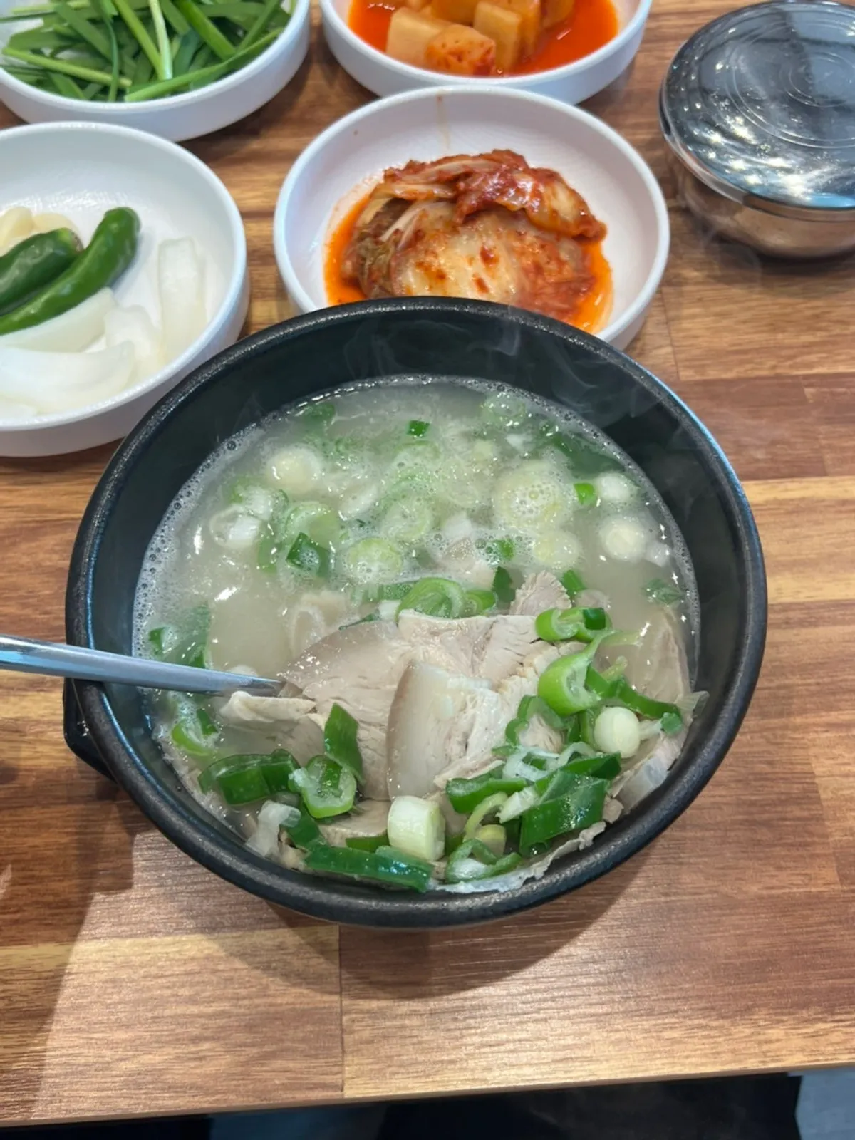 A full spread of dwaeji gukbap in front of Busan Station