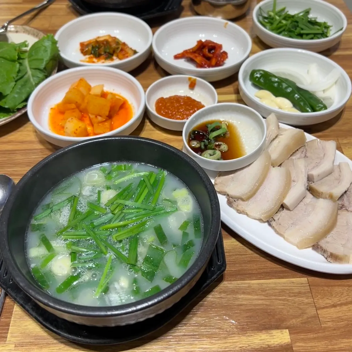 Suyuk baekban broth topped with chives and green onion