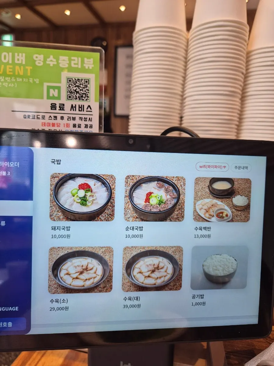 Vertical shot of the dwaeji gukbap and milmyeon menu board