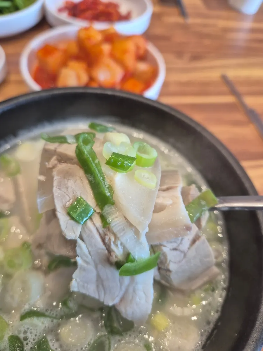 A steaming bowl of dwaeji gukbap
