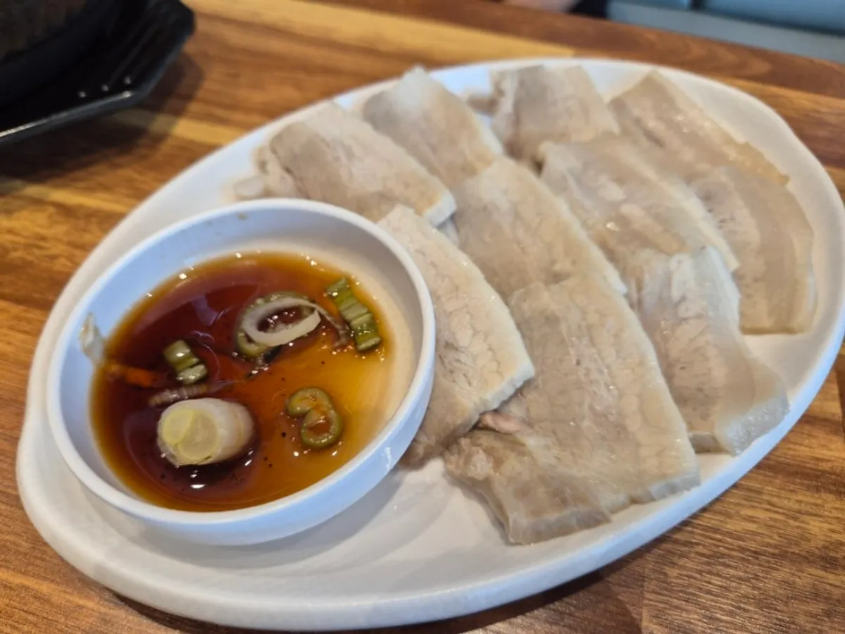 A plate of warm boiled pork with side dishes