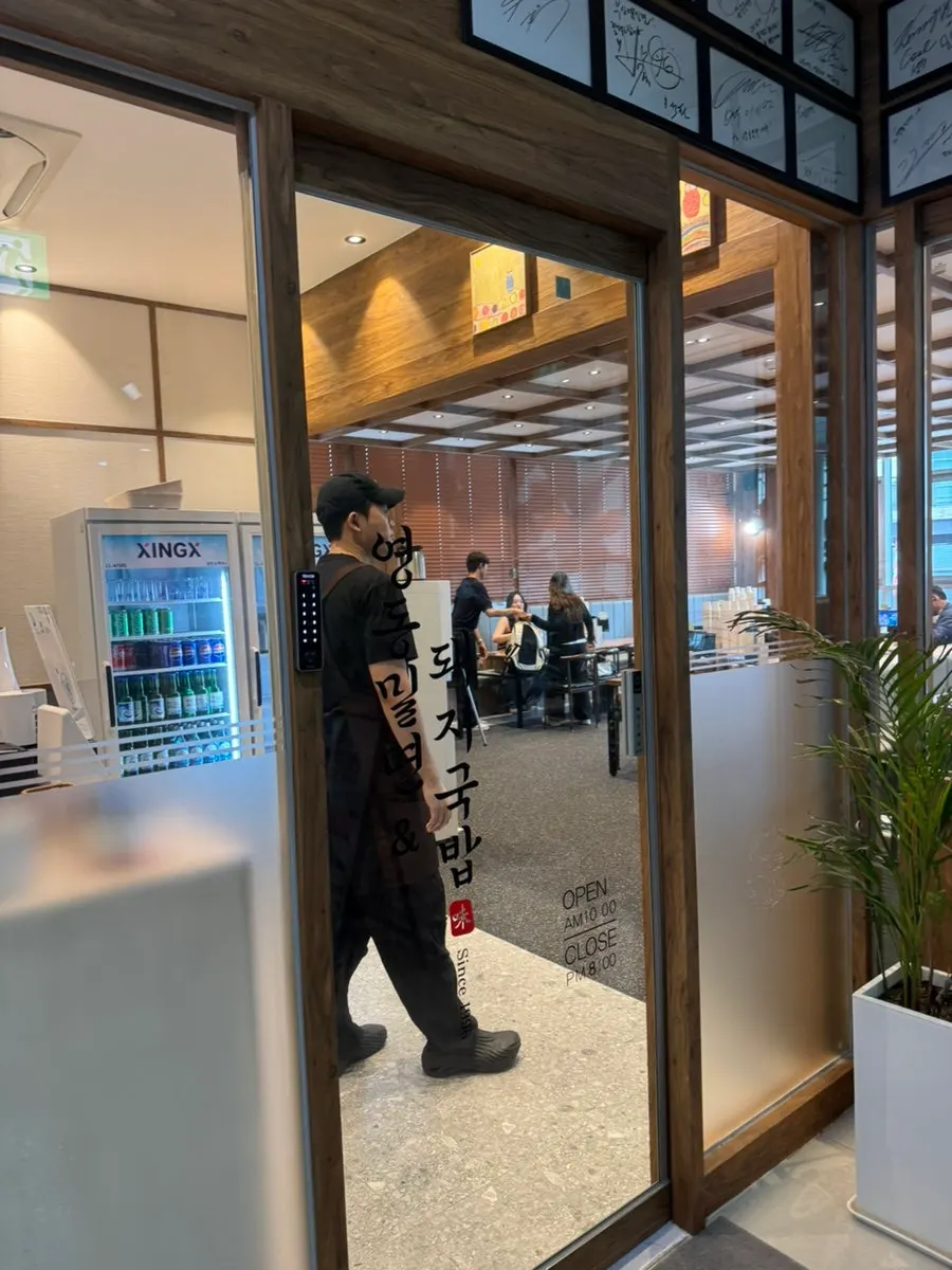Eskalator di depan gedung dan penunjuk lokasi restoran