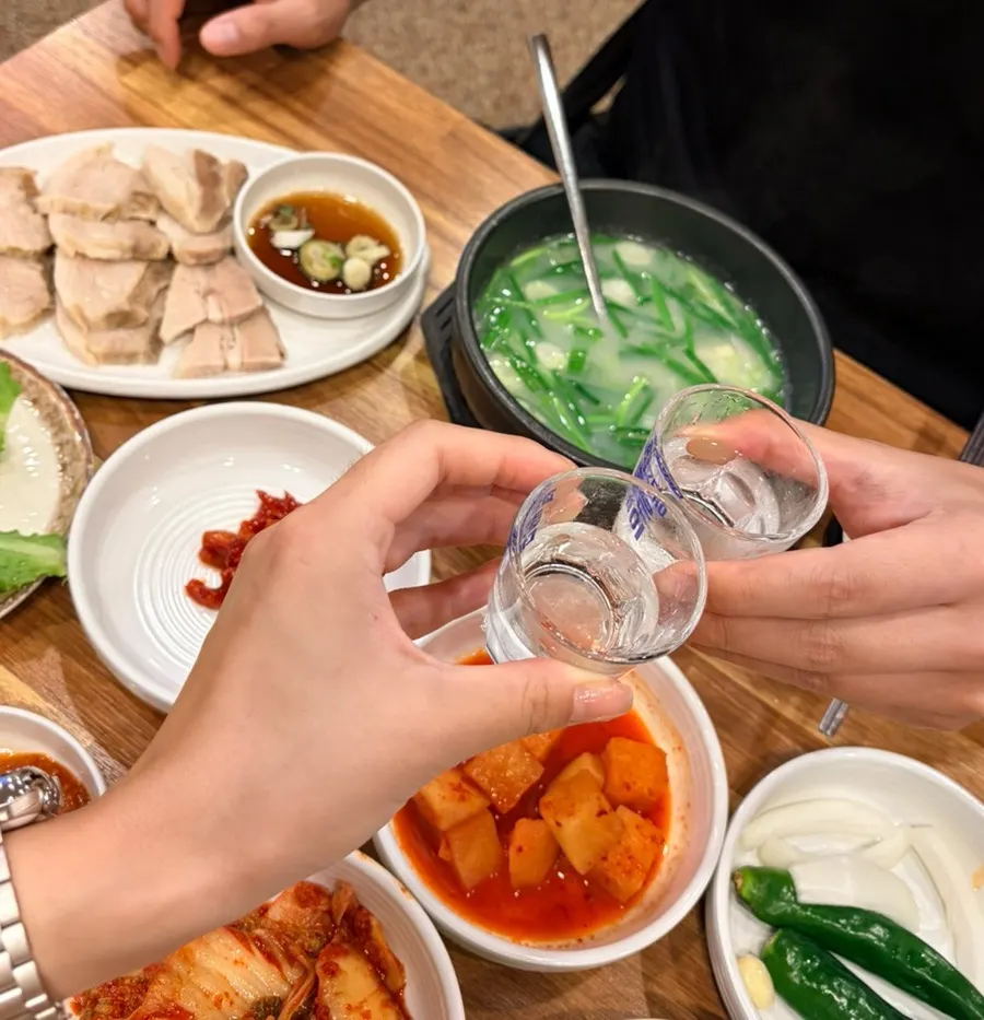 A glass of soju paired with pork wraps