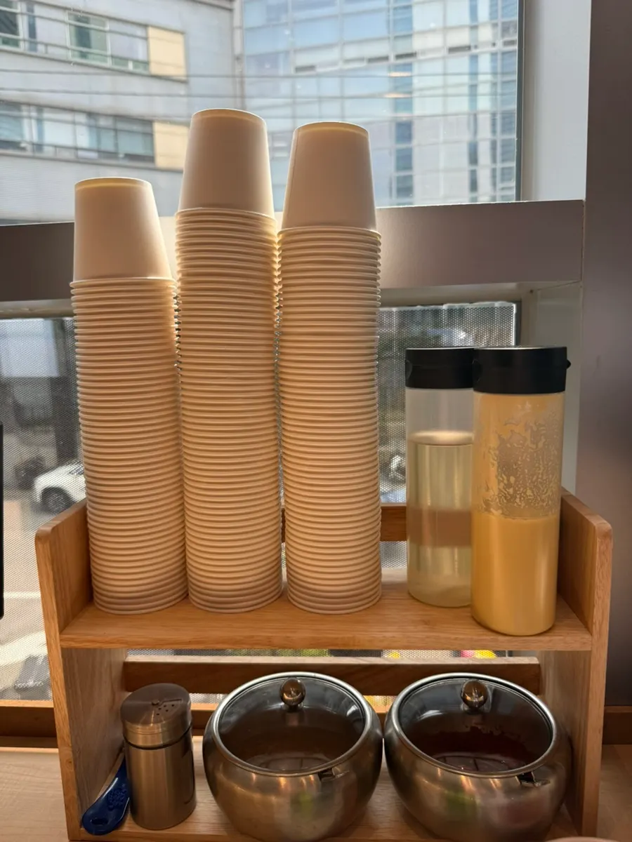 Sauce, paper cups and water set out on each table