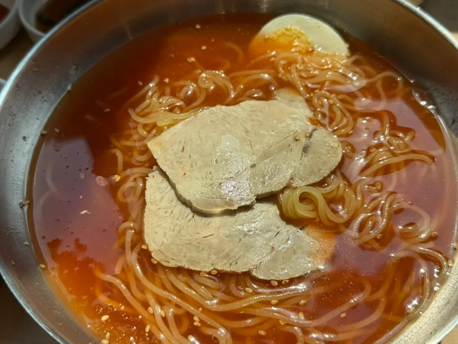 A chopstick-load of mul milmyeon noodles lifted up
