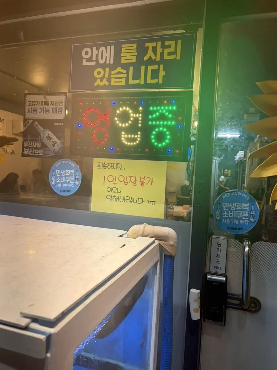 Storefront entrance with a no-solo-entry notice