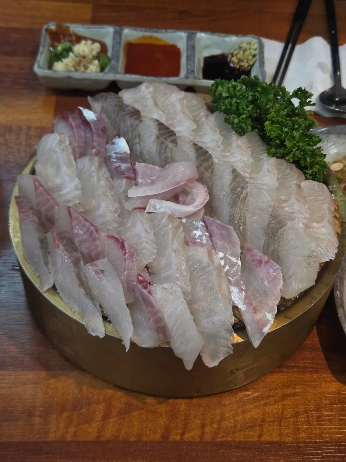 Table set with banchan before the assorted sashimi arrives