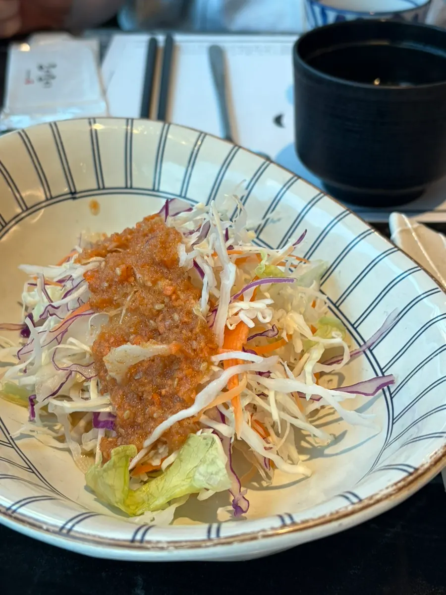 Salad served alongside the sushi