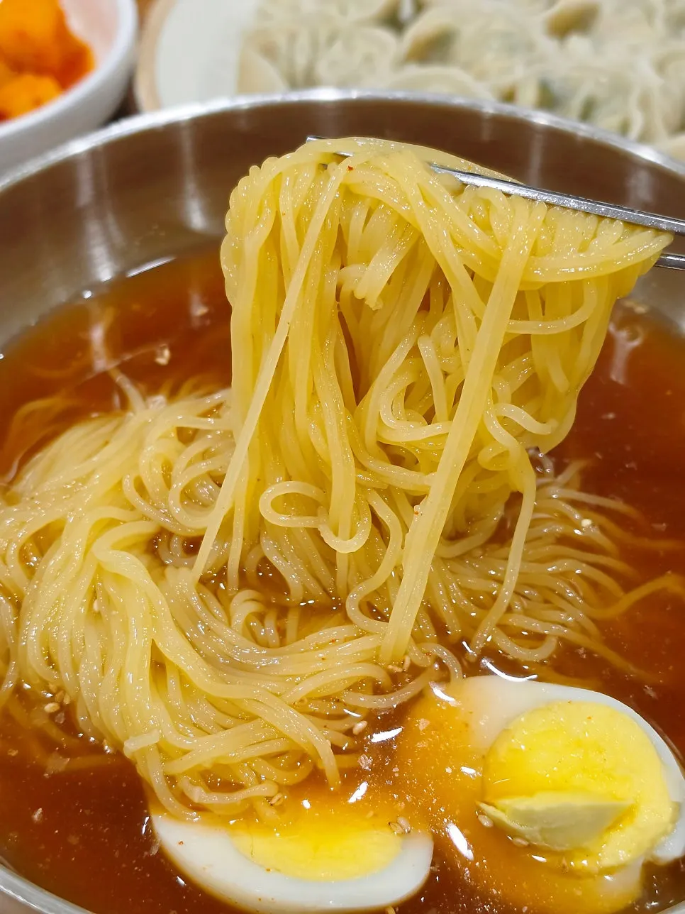 밀면과 반찬이 함께 놓인 테이블