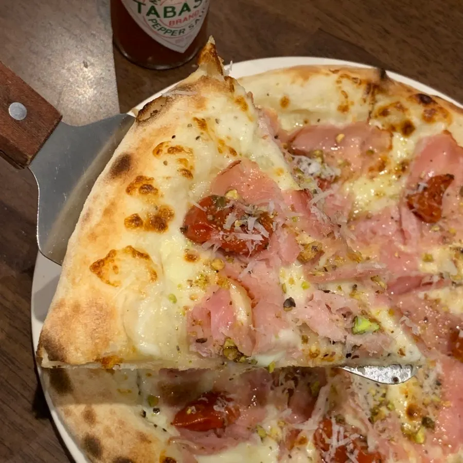 피스타치오 토핑이 올라간 잠봉피자 조각