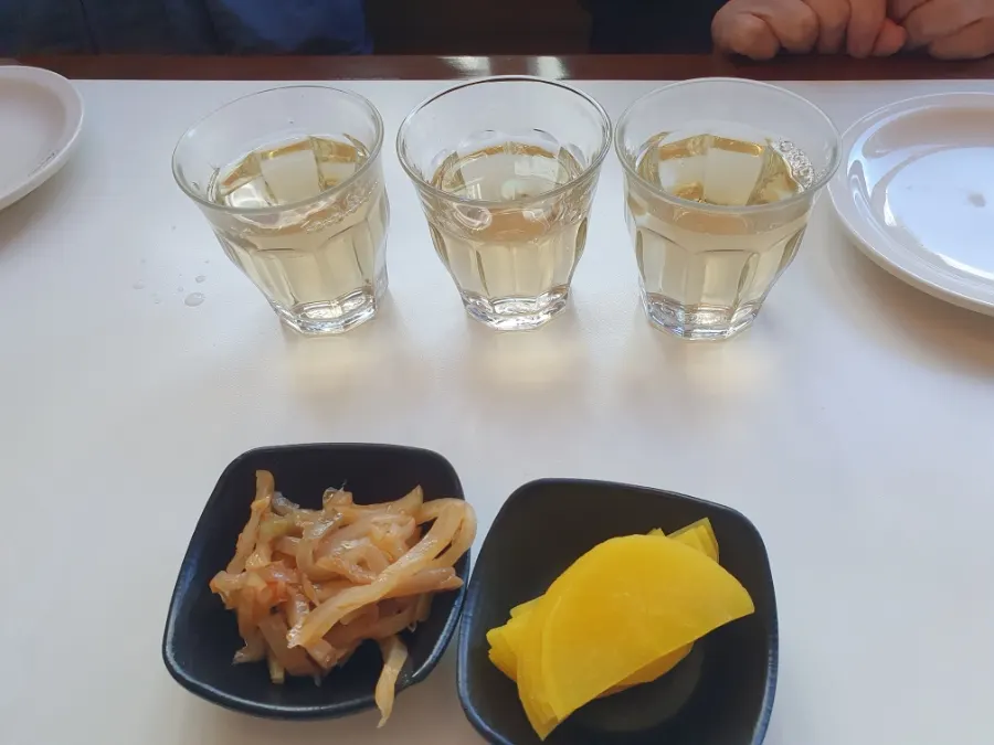 Side dishes jachai and pickled radish with a water glass